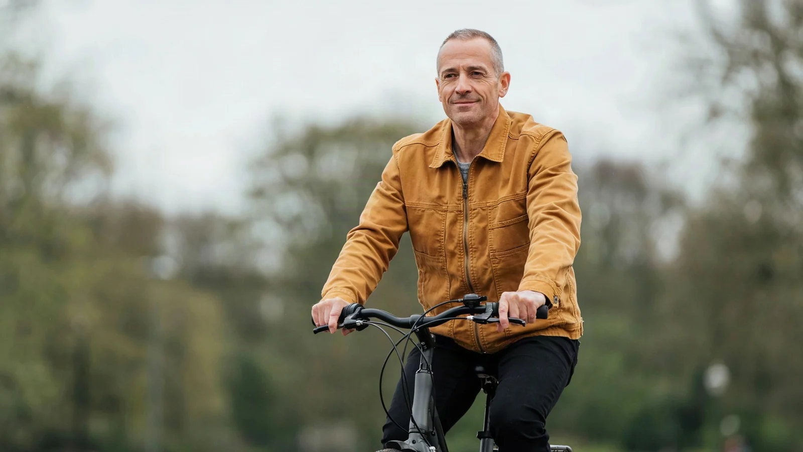 A man riding a bicycle through a park