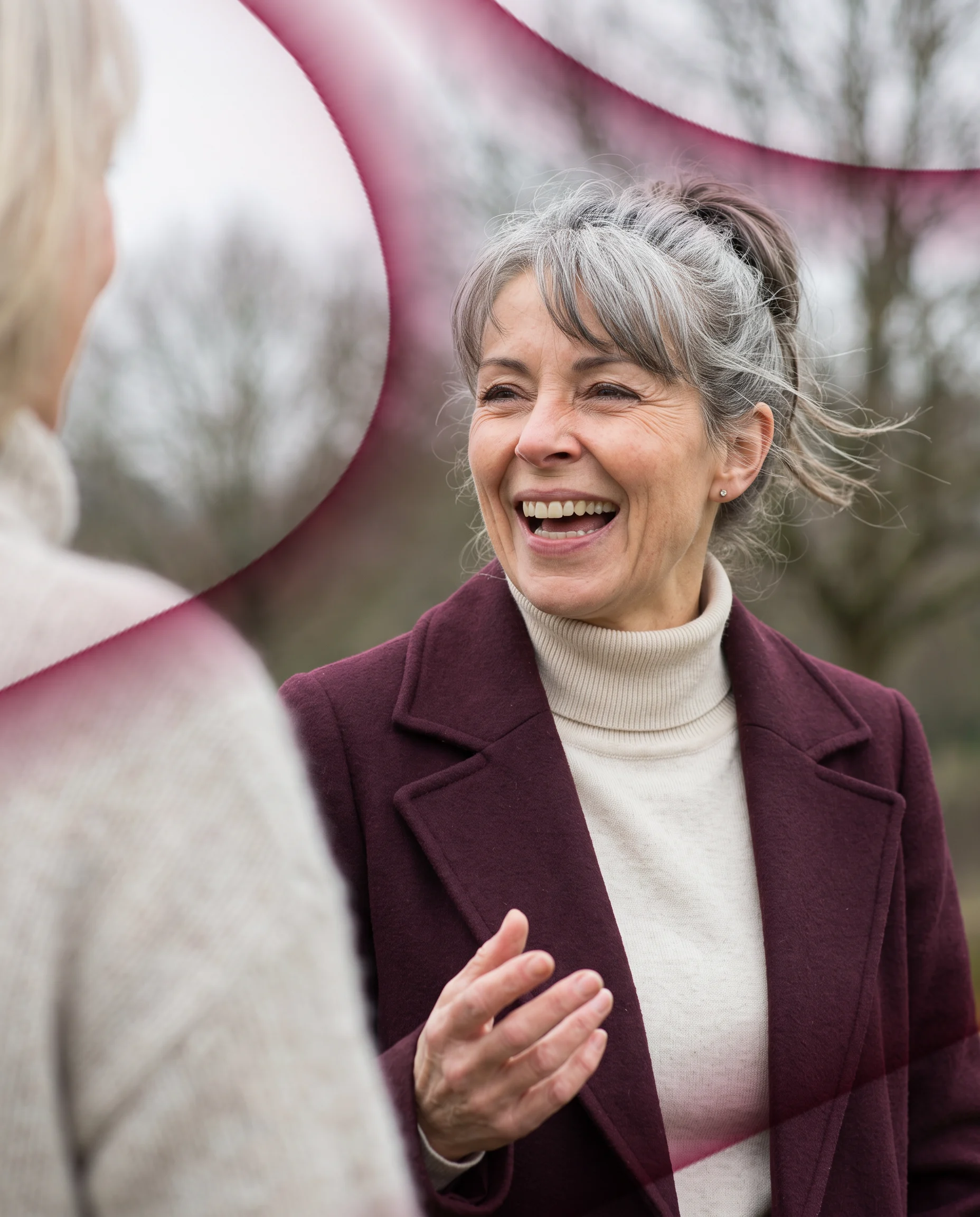 A woman in her fifties laughing with a friend on a morning walk